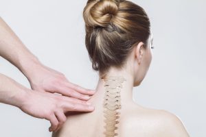 dit is een afbeelding van vingers op rug rondom ruggengraat bij nek. Rugklachten kan een reden zijn waarom je kiest voor aromatouch massage